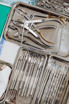 Close-up of organized dental instruments in stainless steel trays, ideal for medical use.